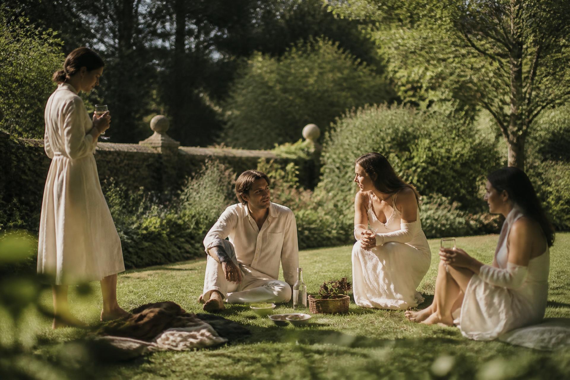 A quiet gathering in an English botanical garden at golden hour